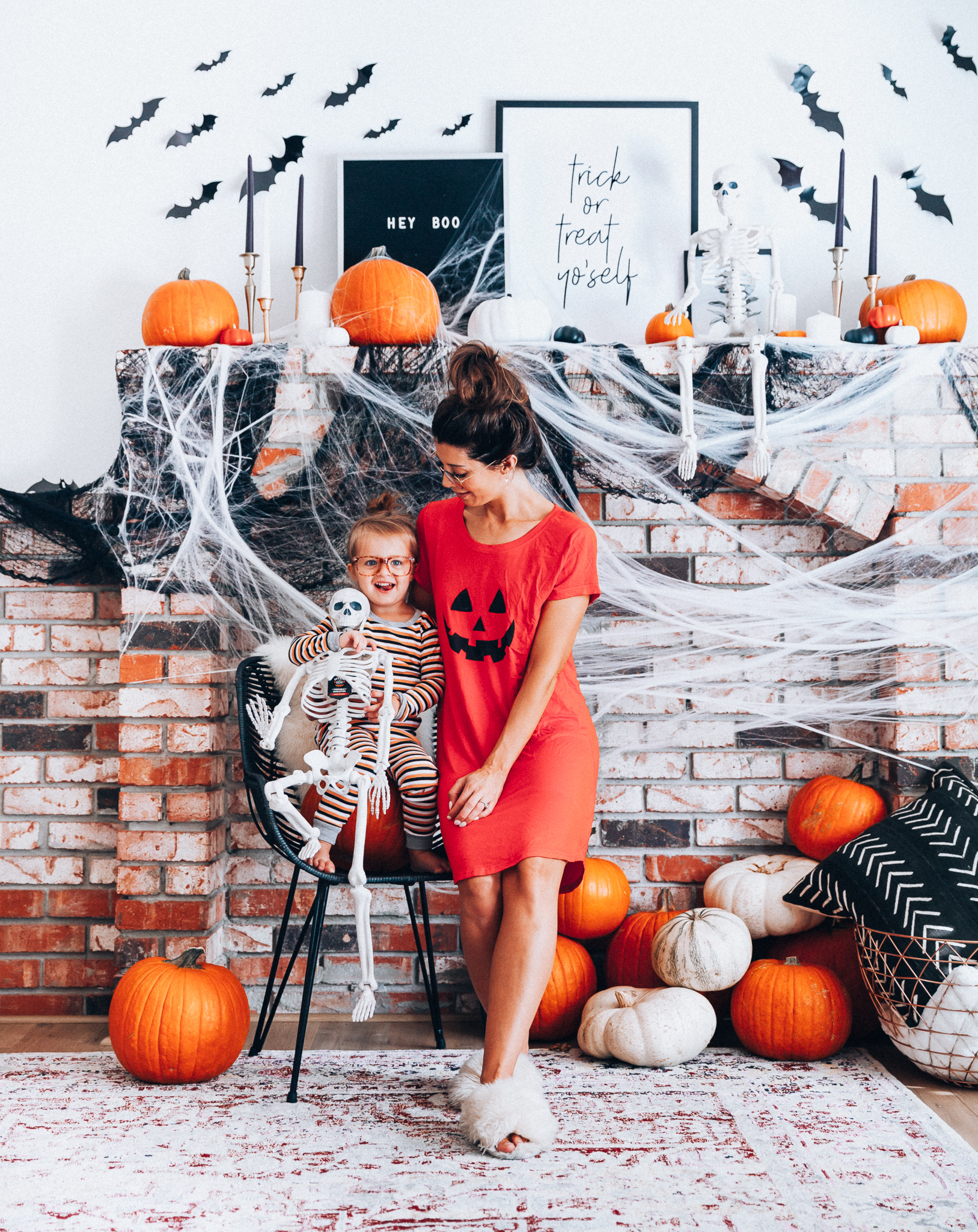 Halloween Mantel Decor + FREE Halloween Printable! by popular San Francisco lifestyle blog, The Girl in the Yellow Dress: image of woman and her young daughter sitting in front a their mantel decorated with Target Halloween decor and Amazon 3D bats and wearing Amazon Burt's Bees Baby Baby Pajamas, Tee and Pant 2-Piece PJ Set, Amazon Seekingtag Children Stylish Cute Glasses Frame Without Lenses, Amazon Hotouch Sleepwear Women's Nightgown Cotton Sleep Shirt, Eye Buy Direct FORTUNE Rectangle Tortoise Eyeglasses, and Nordstrom Patricia Green Mt. Hood Genuine Shearling Slipper.