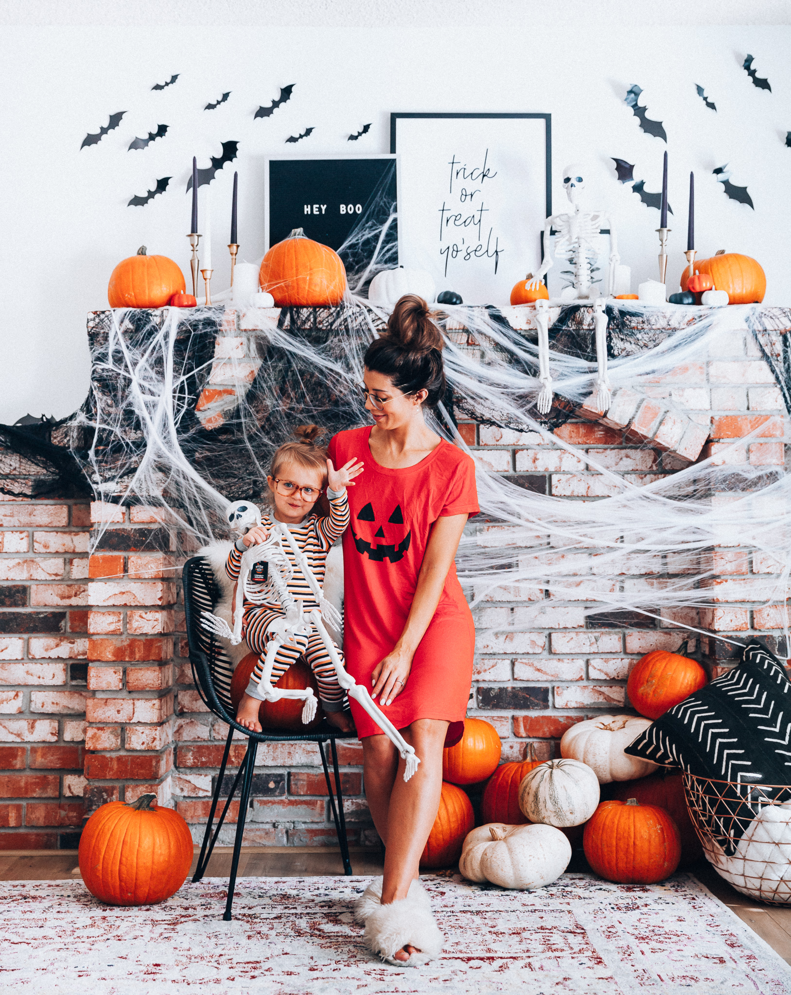 Halloween Mantel Decor + FREE Halloween Printable! by popular San Francisco lifestyle blog, The Girl in the Yellow Dress: image of woman and her young daughter sitting in front a their mantel decorated with Target Halloween decor and Amazon 3D bats and wearing Amazon Burt's Bees Baby Baby Pajamas, Tee and Pant 2-Piece PJ Set, Amazon Seekingtag Children Stylish Cute Glasses Frame Without Lenses, Amazon Hotouch Sleepwear Women's Nightgown Cotton Sleep Shirt, Eye Buy Direct FORTUNE Rectangle Tortoise Eyeglasses, and Nordstrom Patricia Green Mt. Hood Genuine Shearling Slipper.