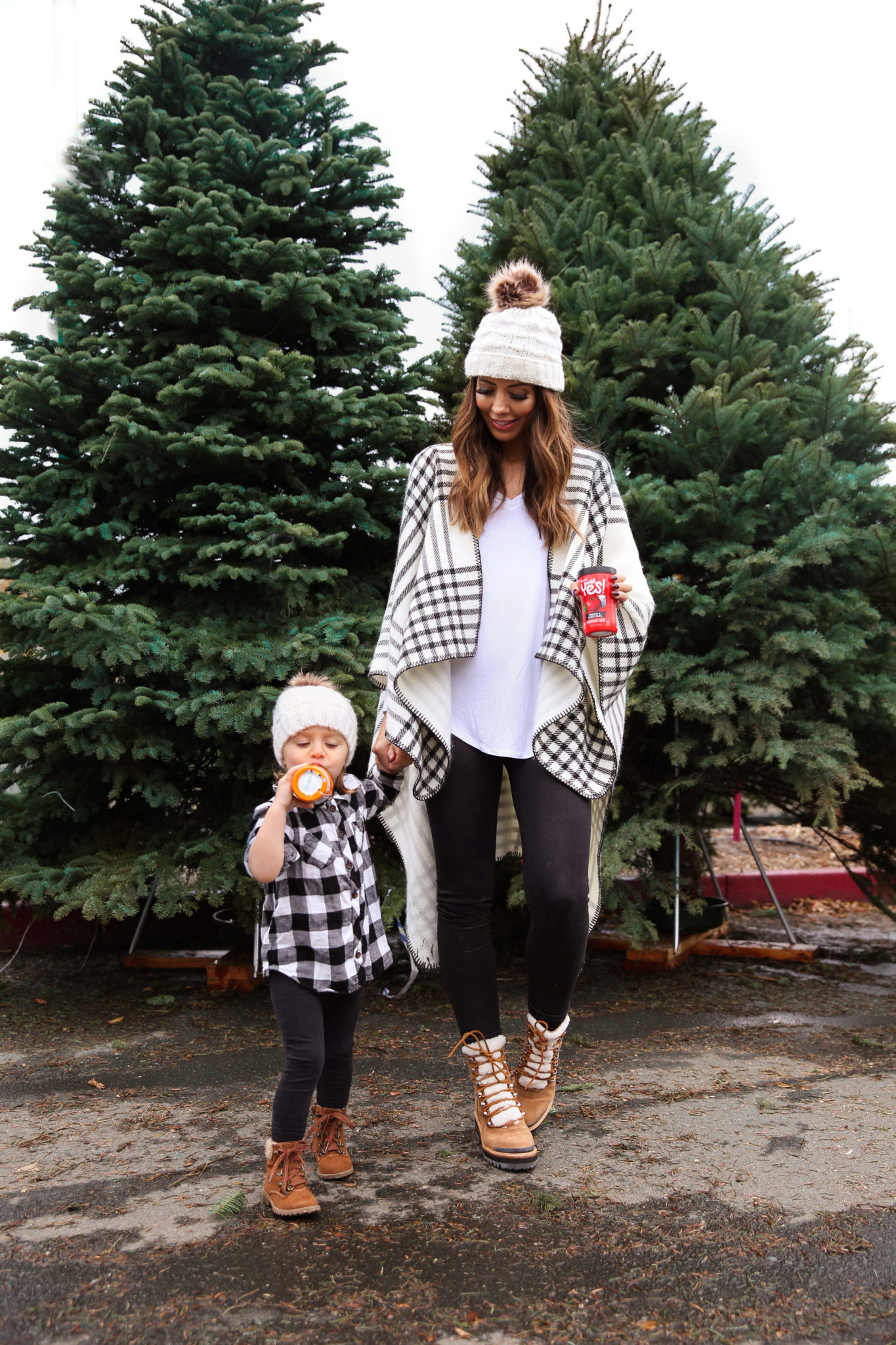 After Christmas....by popular San Francisco life and style blog, The Girl in the Yellow Dress: image of a mom and daughter standing together outside by some pine trees and wearing a JCPenney Mixit Reversible Wrap, Nordstrom Caslon Cozy V-Neck Ribbed Top, Nordstrom Zella Live In High Waist Leggings, Nordstrom Marc Fisher LTD Izzie Genuine Shearling Lace-Up Boot, Amazon Petyoung 2 Pack Parent-Child Knit Hat Mother & Child Baby Family Matching Cap Winter Warm Crochet Beanie Hat with Pom Pom, Amazon Essentials Girls 3-Pack Leggings, and Target Cat & Jack Toddler Girls' Cherish Fashion Boots.