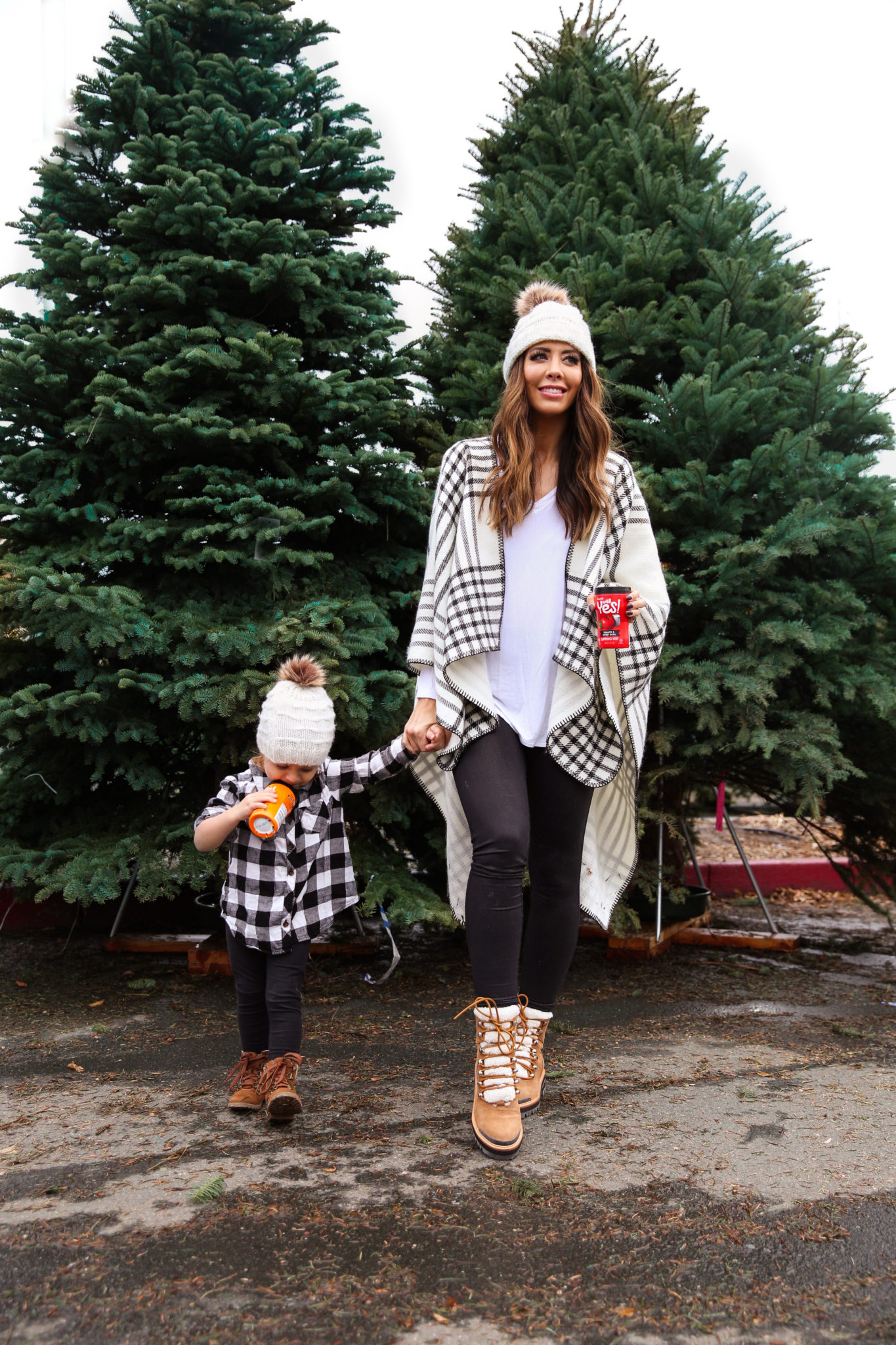 After Christmas....by popular San Francisco life and style blog, The Girl in the Yellow Dress: image of a mom and daughter standing together outside by some pine trees and wearing a JCPenney Mixit Reversible Wrap, Nordstrom Caslon Cozy V-Neck Ribbed Top, Nordstrom Zella Live In High Waist Leggings, Nordstrom Marc Fisher LTD Izzie Genuine Shearling Lace-Up Boot, Amazon Petyoung 2 Pack Parent-Child Knit Hat Mother & Child Baby Family Matching Cap Winter Warm Crochet Beanie Hat with Pom Pom, Amazon Essentials Girls 3-Pack Leggings, and Target Cat & Jack Toddler Girls' Cherish Fashion Boots.