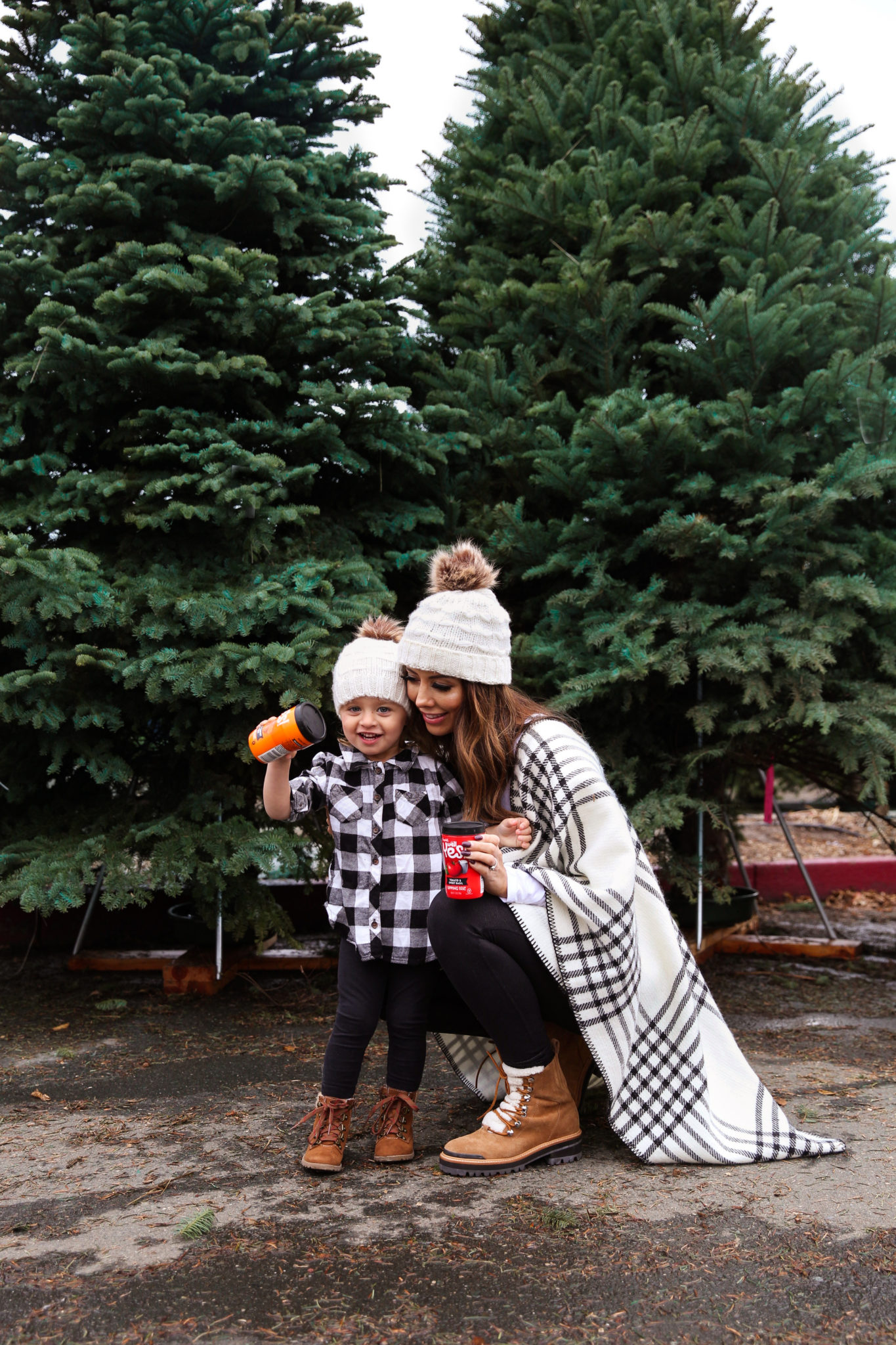 After Christmas....by popular San Francisco life and style blog, The Girl in the Yellow Dress: image of a mom and daughter standing together outside by some pine trees and wearing a JCPenney Mixit Reversible Wrap, Nordstrom Caslon Cozy V-Neck Ribbed Top, Nordstrom Zella Live In High Waist Leggings, Nordstrom Marc Fisher LTD Izzie Genuine Shearling Lace-Up Boot, Amazon Petyoung 2 Pack Parent-Child Knit Hat Mother & Child Baby Family Matching Cap Winter Warm Crochet Beanie Hat with Pom Pom, Amazon Essentials Girls 3-Pack Leggings, and Target Cat & Jack Toddler Girls' Cherish Fashion Boots.