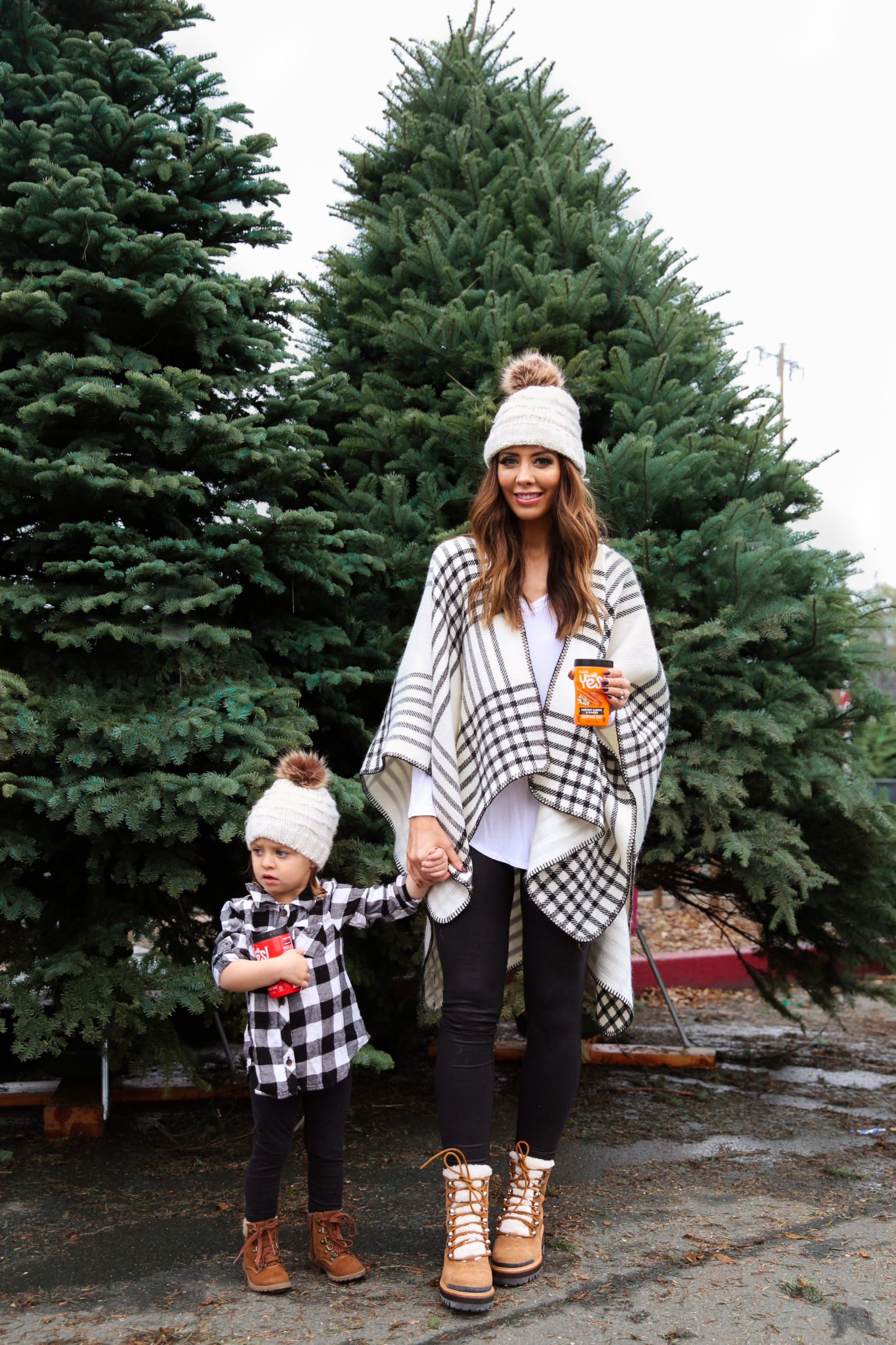 After Christmas....by popular San Francisco life and style blog, The Girl in the Yellow Dress: image of a mom and daughter standing together outside by some pine trees and wearing a JCPenney Mixit Reversible Wrap, Nordstrom Caslon Cozy V-Neck Ribbed Top, Nordstrom Zella Live In High Waist Leggings, Nordstrom Marc Fisher LTD Izzie Genuine Shearling Lace-Up Boot, Amazon Petyoung 2 Pack Parent-Child Knit Hat Mother & Child Baby Family Matching Cap Winter Warm Crochet Beanie Hat with Pom Pom, Amazon Essentials Girls 3-Pack Leggings, and Target Cat & Jack Toddler Girls' Cherish Fashion Boots.