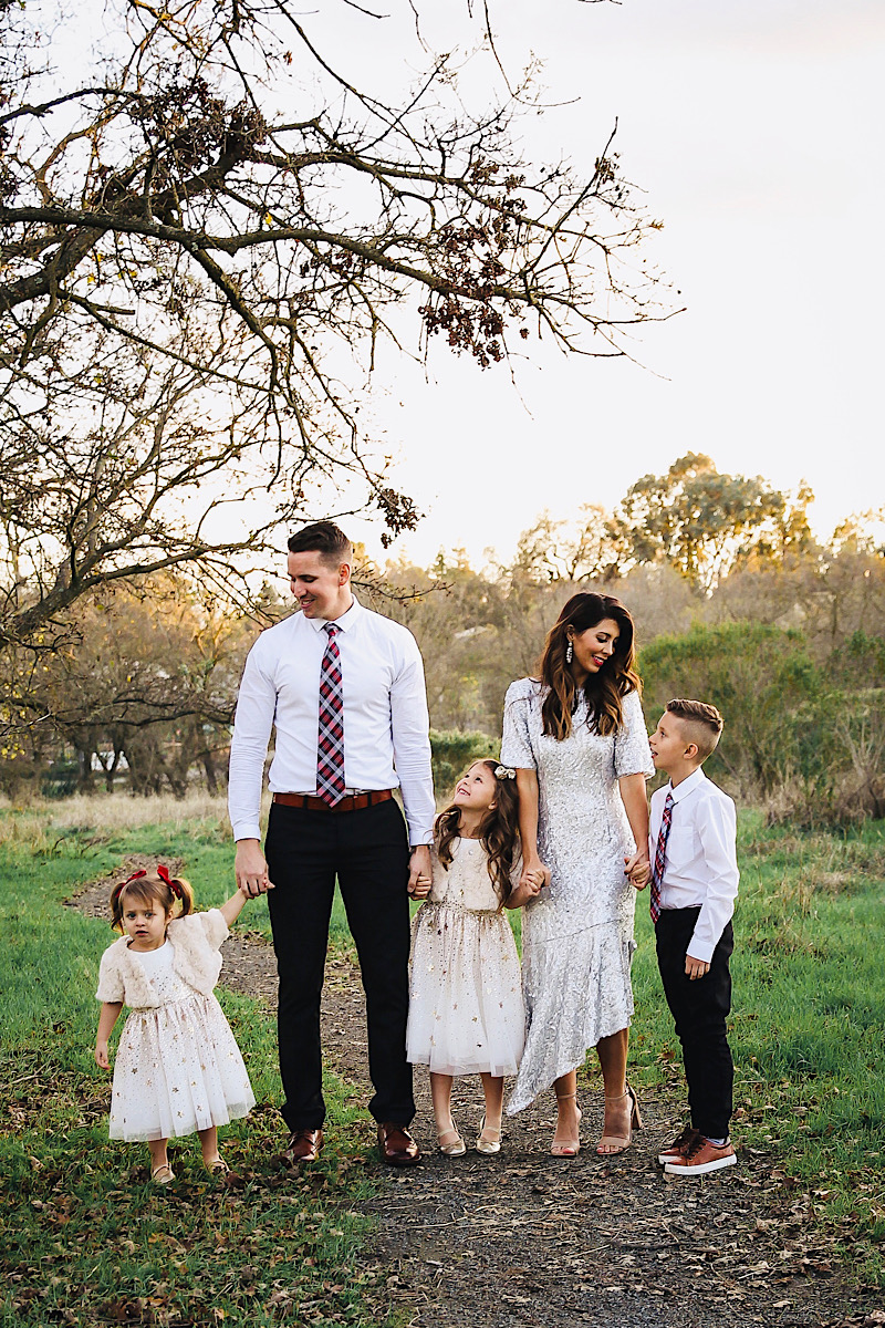 Merry Christmas Wishes 2019 by popular San Francisco life and style blog, The Girl in the Yellow Dress: image of a family standing together outside in a grassy field and wearing Nordstrom Sam Edelman Yaro Ankle Strap Sandals, H&M Earrings with Beads, Express Slim Solid Wrinkle-Resistant Performance Dress Shirt, Nordstrom Topman Skinny Fit Textured Dress Pants, Nordstrom Magnanni 'Lamont' Cap Toe Oxford, Nordstrom Ted Baker London Plaid Silk Tie, H&M Sequined Tulle Dress, and Amazon THEE BRON Girl's Toddler/Little Kid Ballet Mary Jane Flat Shoes.