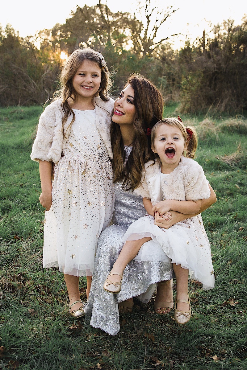 Merry Christmas Wishes 2019 by popular San Francisco life and style blog, The Girl in the Yellow Dress: image of a mom and her two daughters standing together outside in a grassy field and wearing Nordstrom Sam Edelman Yaro Ankle Strap Sandals, H&M Earrings with Beads, H&M Sequined Tulle Dress, and Amazon THEE BRON Girl's Toddler/Little Kid Ballet Mary Jane Flat Shoes.