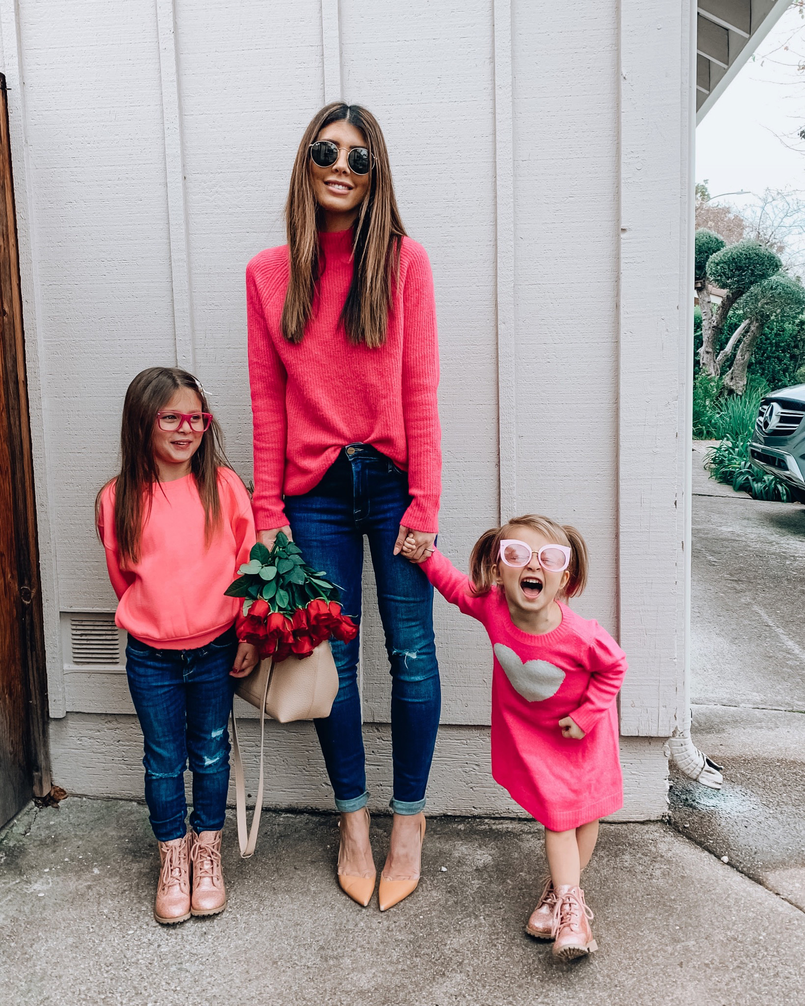 Mommy and Me Valentine's Day Outfits by popular San Francisco fashion blog, The Girl in the Yellow Dress: image of a mom and her two daughters wearing Nordstrom Mock Neck Sweater HALOGEN®, Evereve Frame Le High Skinny, Nordstrom Jaina Pump SAM EDELMAN, Nordstrom Icons 53mm Retro Sunglasses RAY-BAN, Nordstrom Iside Mini Top Handle Bag VALEXTRA, Nordstrom Neon Chunky Knit Sweater COTTON EMPORIUM, Old Navy Ballerina Built-In Tough Distressed Jeggings for Girls, Dr. Martens 1460 Boot, and Gap heart sweater dress.