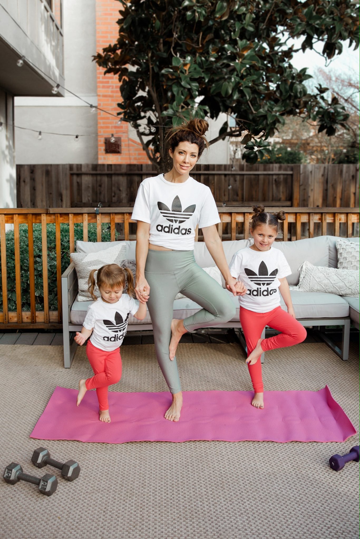 Best Fitness Tips for Moms by popular San Francisco life and style blog, The Girl in the Yellow Dress: image of a mom and her two daughters wearing Amazon Reebok Women's Capri Workout Leggings w/High-Rise Waist, Nordstrom adidas Trefoil Tee ADIDAS ORIGINALS, Amazon Essentials Girls' 3-Pack Legging, Amazon adidas Originals Boys' Kids Trefoil Tee, and Amazon adidas Originals Kids' Trefoil Tee while working out on a Amazon ProsourceFit Extra Thick Yoga and Pilates Mat.