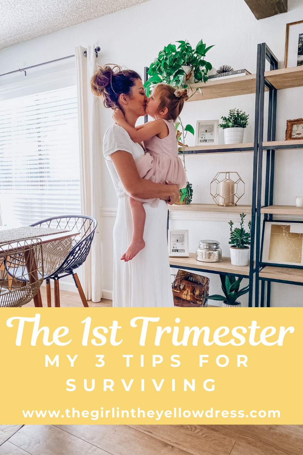 First Trimester Survival by popular San Francisco lifestyle blog, The Girl in the Yellow Dress: image of a woman wearing a white Nordstrom Blouson Dress WAYF and holding her young daughter as they standing in their home that's decorated with a World Market Natural Macrame Table Runner, Target 72" Loring 5 Shelf Ladder Bookcase, Amazon Nearly Natural 4762 44in. Philodendron Hanging Basket Silk Plant, Target Ceramic Planter White, and CB2 SIDERA CHAIR.