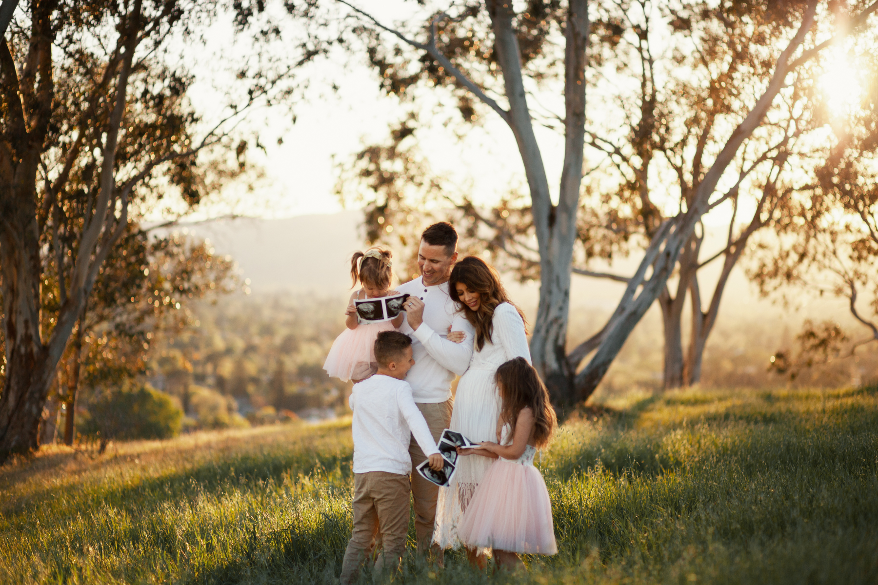 Family Pregnancy Announcement by popular San Francisco lifestyle blog, The Girl in the Yellow Dress: image of a family standing in a field, holding ultra sound photos and wearing a Nordstrom Yaro Ankle Strap Sandal SAM EDELMAN, Old Navy Soft-Washed Long-Sleeve Henley for Men, Aerie AE NE(X)T LEVEL KHAKI JOGGER, Nordstrom GrandPro Low Top Sneaker COLE HAAN, Amazon Flofallzique Baby Girls Dress Toddler Tutu Infant Floral Sundress Tulle Wedding Dress, Freshly Picked White Patent Malibu, Old Navy Softest Crew-Neck Long-Sleeve Tee for Boys, and Old Navy Built-In Flex Twill Joggers for Boys.