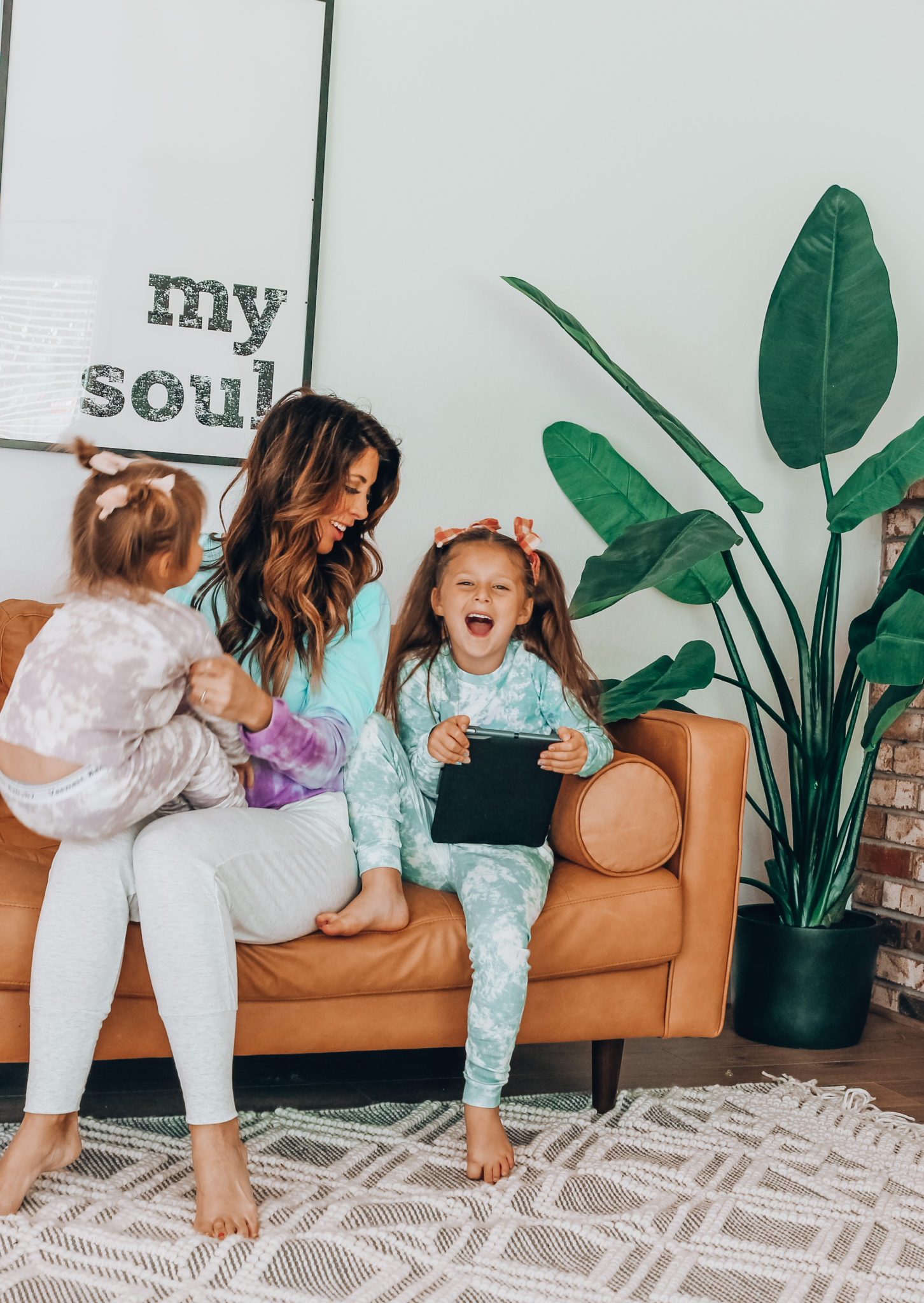 Messenger Kids Review by popular San Francisco lifestyle blog,The Girl in the Yellow Dress: image of a mom and her two daughters sitting together and holding a tablet. 