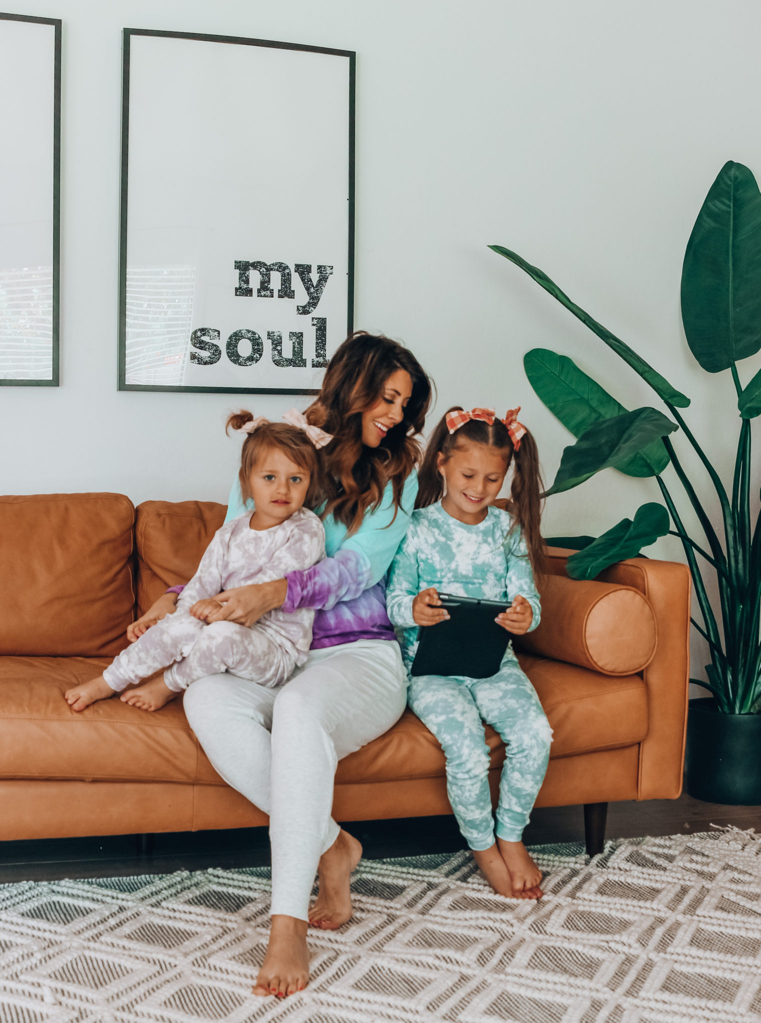 Messenger Kids Review by popular San Francisco lifestyle blog,The Girl in the Yellow Dress: image of a mom and her two daughters sitting together on a couch and holding a tablet. 