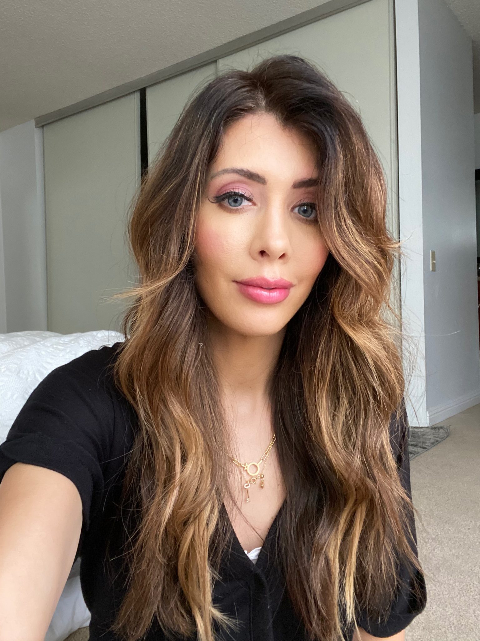 How to Touch Up Roots by popular San Francisco beauty blog, The Girl in the Yellow Dress: image of a woman in a black shirt with brown wavy hair. 